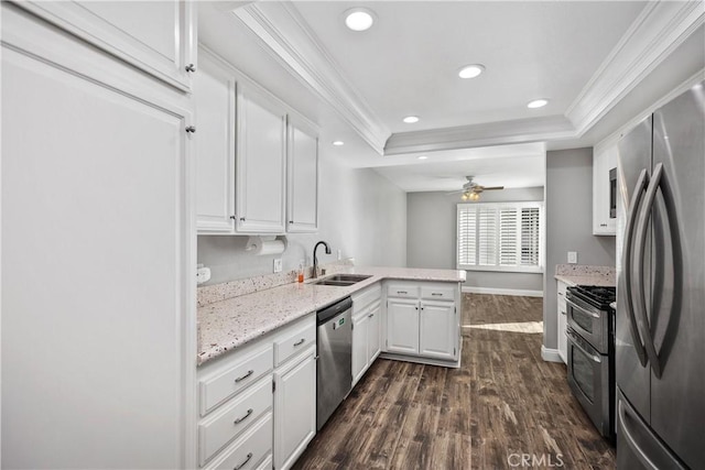 kitchen featuring appliances with stainless steel finishes, white cabinetry, sink, kitchen peninsula, and a raised ceiling