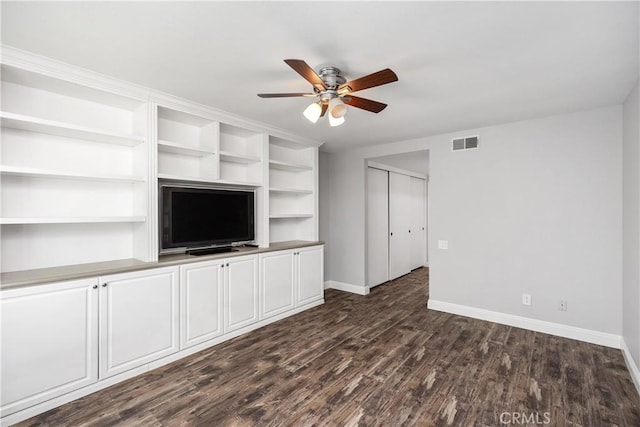 unfurnished living room featuring ceiling fan and dark hardwood / wood-style floors