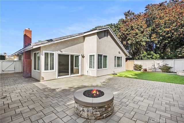 rear view of house featuring a patio area and a fire pit