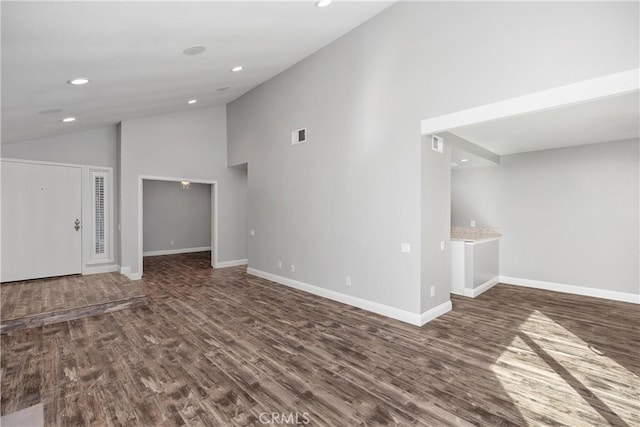 unfurnished living room featuring high vaulted ceiling and dark hardwood / wood-style floors