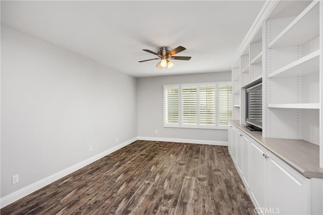 unfurnished room with ceiling fan and dark wood-type flooring