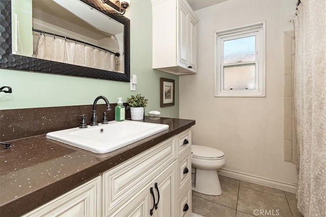 bathroom featuring toilet, vanity, and tile patterned flooring