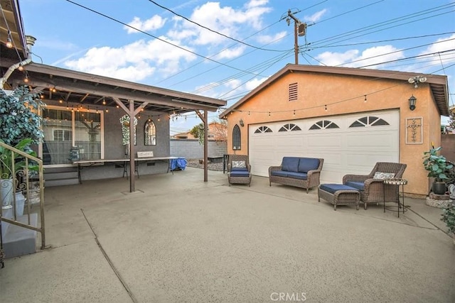 view of patio with a garage and an outbuilding