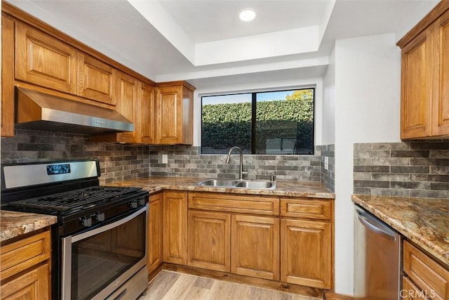 33611 Dana Vista Dr Unit 31, Dana Point, CA 92629 - kitchen with appliances with stainless steel finishes, extractor fan, brown cabinetry, and light stone countertops