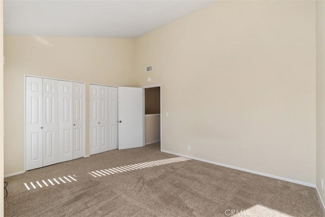 33611 Dana Vista Dr Unit 31, Dana Point, CA 92629 - unfurnished bedroom featuring two closets, high vaulted ceiling, and carpet flooring