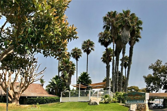 view of home's community with a yard and fence