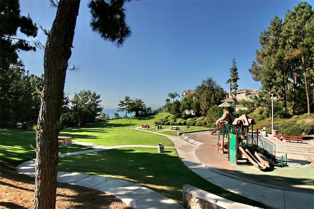 view of property's community with playground community and a lawn