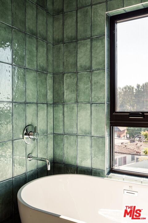 bathroom featuring a bathing tub and tile walls