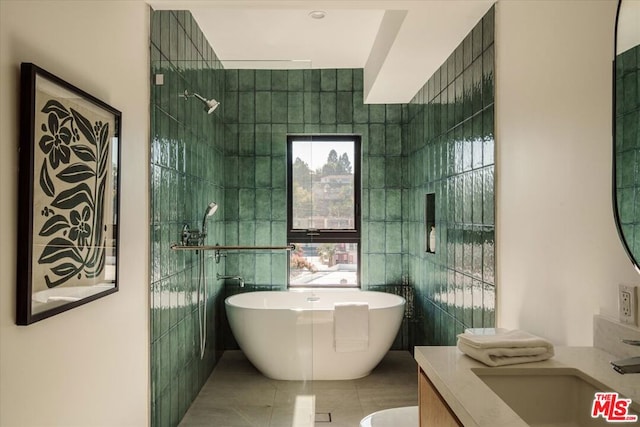 bathroom featuring tile patterned flooring, vanity, tile walls, and a bathing tub