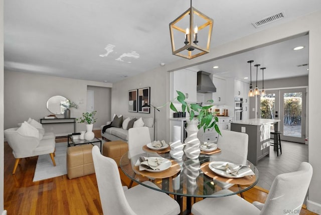 dining space featuring french doors, a notable chandelier, and hardwood / wood-style floors