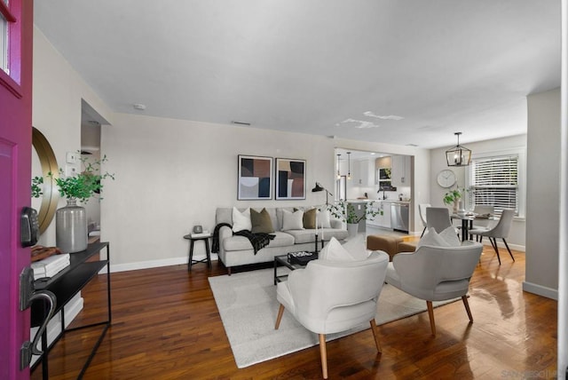 living room featuring dark wood-type flooring and a notable chandelier