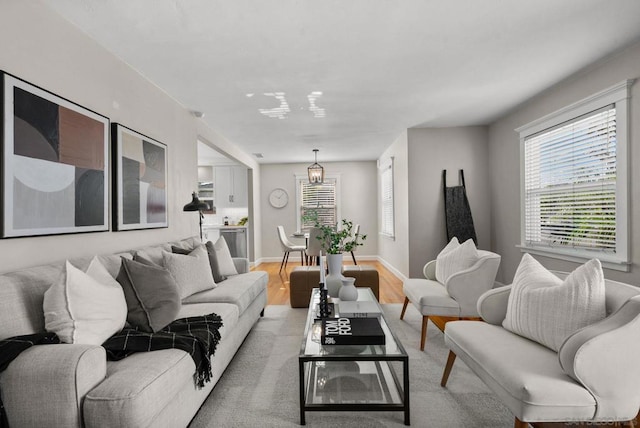 living room with light hardwood / wood-style floors and an inviting chandelier