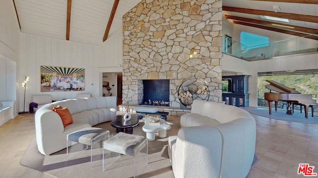 living room featuring beam ceiling, a stone fireplace, and high vaulted ceiling