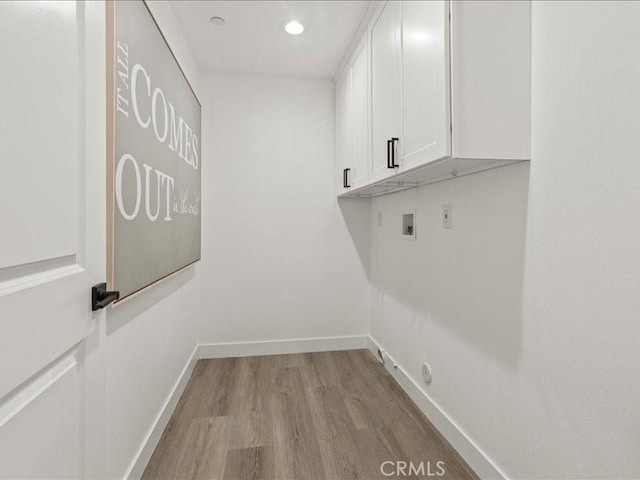 laundry area featuring cabinets, light hardwood / wood-style flooring, and hookup for a washing machine