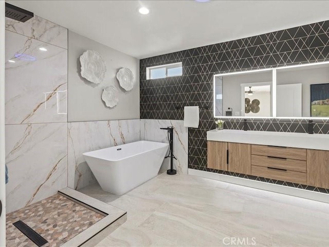 bathroom featuring tile walls, vanity, and plus walk in shower