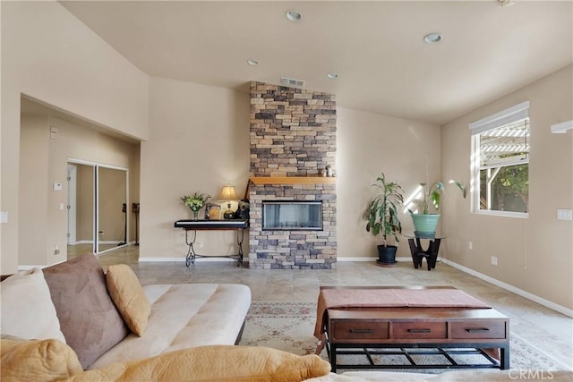 living room featuring lofted ceiling and a stone fireplace