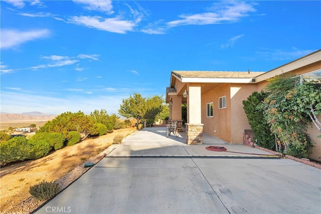 view of home's exterior with a patio area and a mountain view