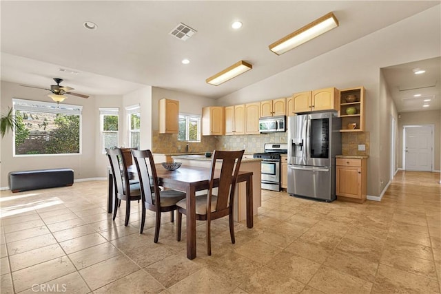 tiled dining room featuring ceiling fan and vaulted ceiling