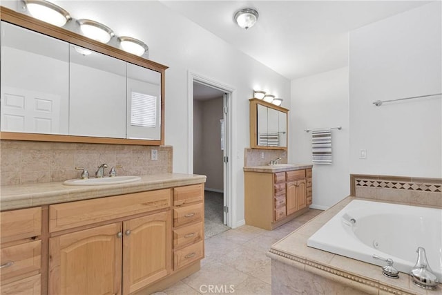 bathroom with tiled bath, tile patterned flooring, decorative backsplash, and vanity