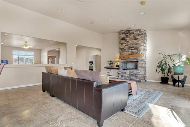 living room with ceiling fan and a fireplace