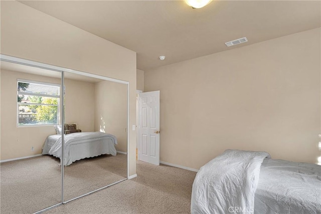 bedroom with light colored carpet and a closet