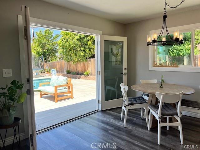 dining space featuring dark wood-type flooring and a chandelier