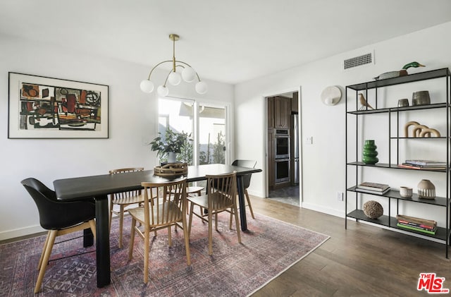 dining space with an inviting chandelier and dark hardwood / wood-style floors