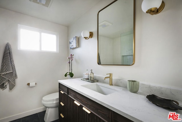 bathroom featuring toilet, vanity, and tile patterned floors