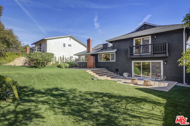 back of house featuring a patio area, a lawn, and a balcony