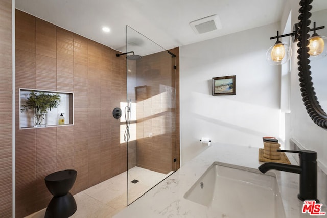 bathroom featuring a tile shower and sink