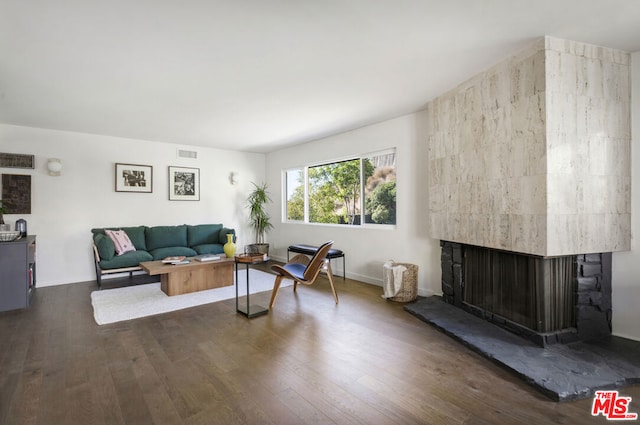 living room with dark hardwood / wood-style flooring and a multi sided fireplace