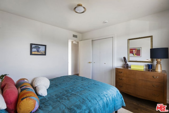 bedroom with a closet and dark hardwood / wood-style floors