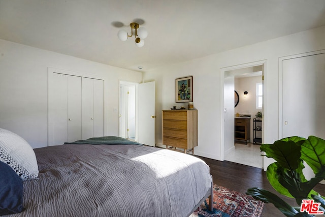 bedroom with dark hardwood / wood-style floors and ensuite bath