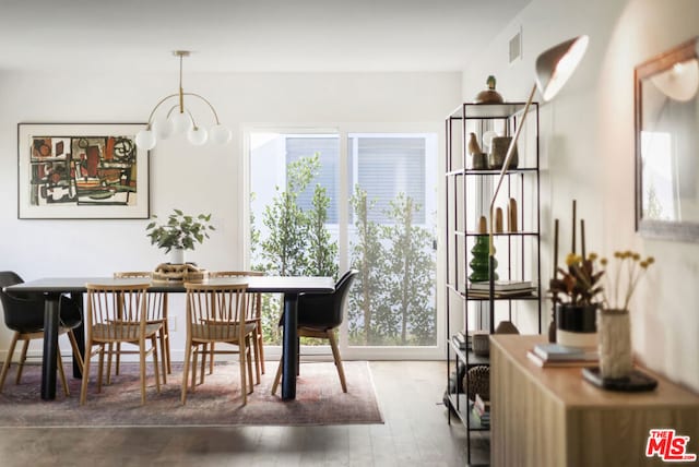 dining room with an inviting chandelier, a wealth of natural light, and hardwood / wood-style flooring