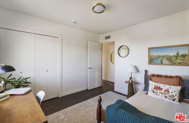 bedroom with dark hardwood / wood-style flooring and a closet