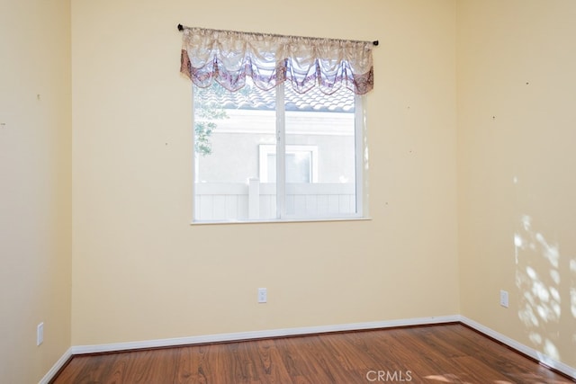 unfurnished room featuring baseboards and wood finished floors