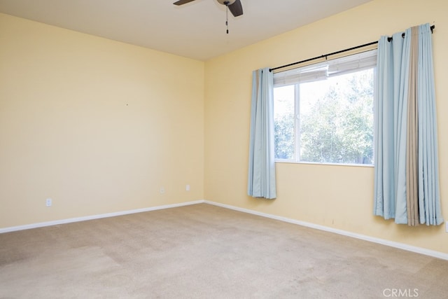 unfurnished room featuring baseboards, a ceiling fan, and light colored carpet