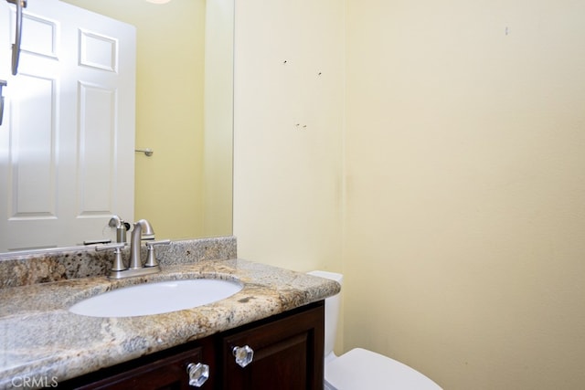 half bathroom featuring toilet and vanity