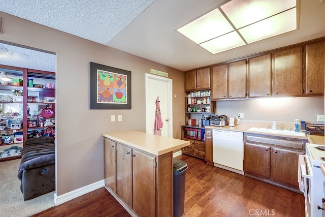 kitchen featuring white appliances, a textured ceiling, sink, dark hardwood / wood-style floors, and kitchen peninsula