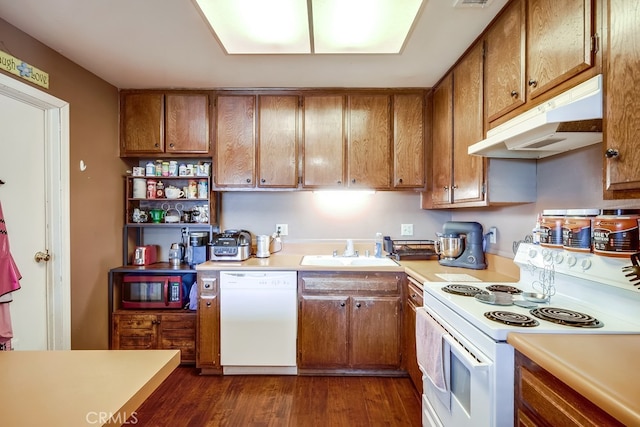 kitchen featuring dark wood-type flooring, sink, and white appliances