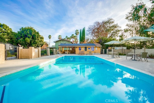 view of swimming pool featuring a patio area and an outbuilding