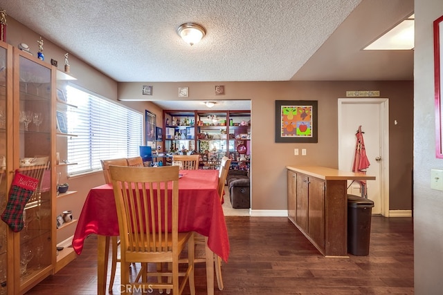 dining area with a textured ceiling and dark hardwood / wood-style floors