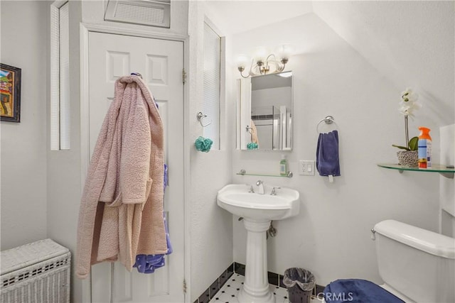 bathroom featuring sink, toilet, vaulted ceiling, and tile patterned floors