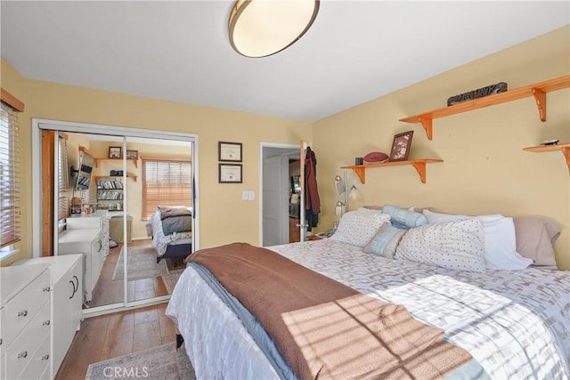 bedroom with a closet, dark hardwood / wood-style floors, and multiple windows