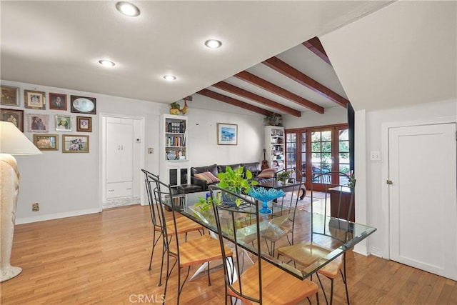 dining room featuring hardwood / wood-style flooring, french doors, and vaulted ceiling with beams