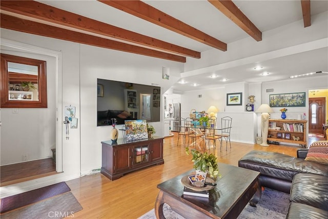 living room featuring light wood-type flooring and beam ceiling