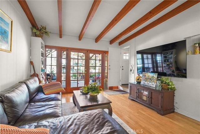 living room with light hardwood / wood-style flooring, beam ceiling, and french doors