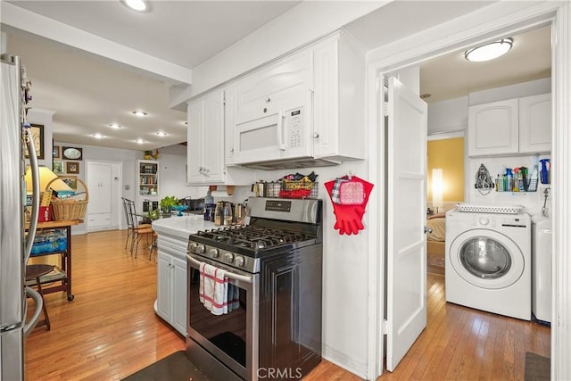 kitchen featuring white cabinetry, washer / dryer, light hardwood / wood-style flooring, and appliances with stainless steel finishes