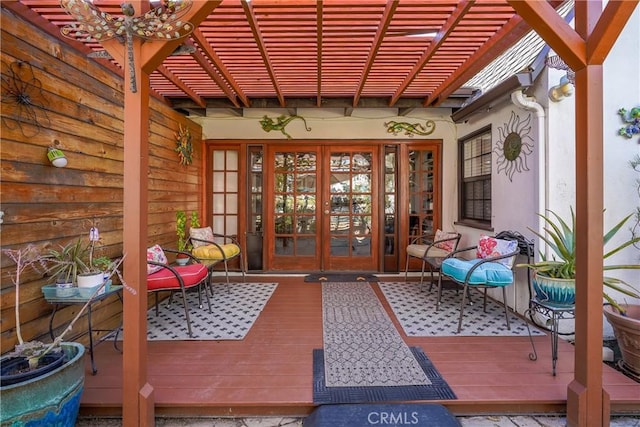 entrance to property featuring a deck, a pergola, and french doors