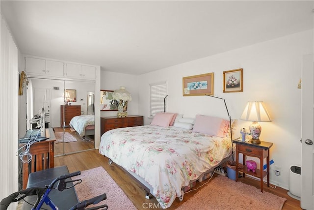 bedroom with light hardwood / wood-style floors and a closet